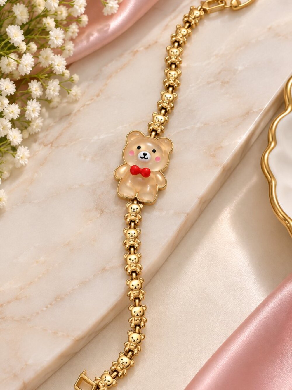A charming light gold-tone bracelet featuring smooth rounded links and a glossy
